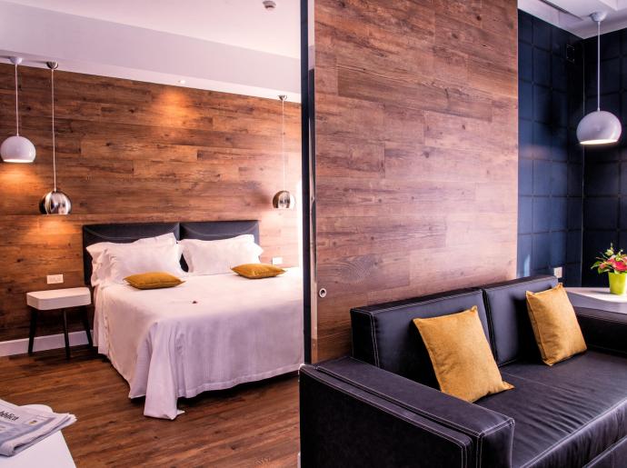 Camera moderna con letto matrimoniale, divano e decorazioni eleganti.