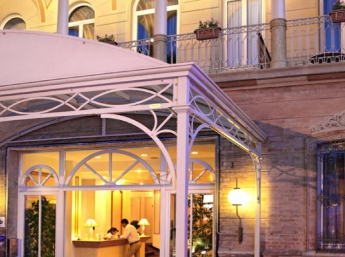 Elegante ingresso di hotel con reception illuminata di sera.