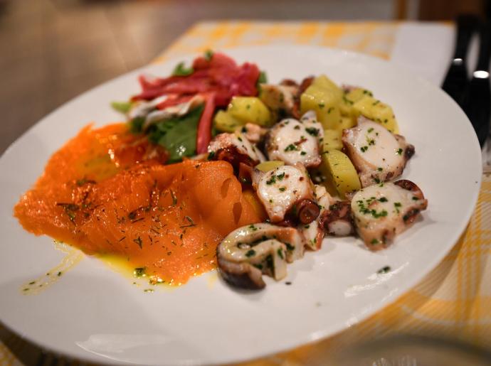 Teller mit geräuchertem Lachs, Oktopus und Gemüse.