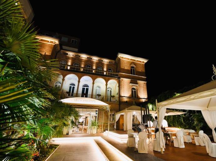 Elegante Villa bei Nacht beleuchtet mit Außenbereich für Veranstaltungen.