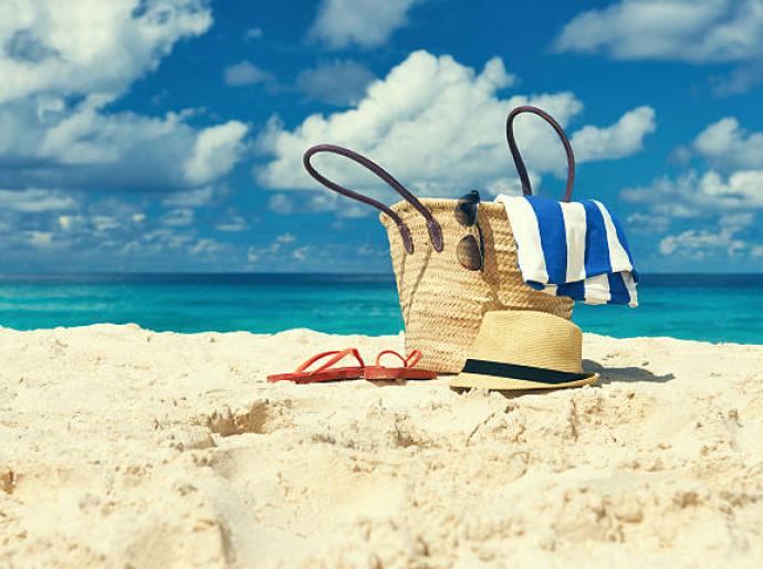 Sonniger Strand, türkisfarbenes Meer, Sommertasche, totale Entspannung und Abenteuer.
