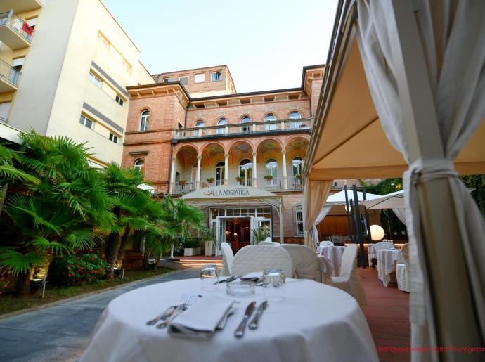 Elegante ristorante all'aperto con vista su una villa storica.