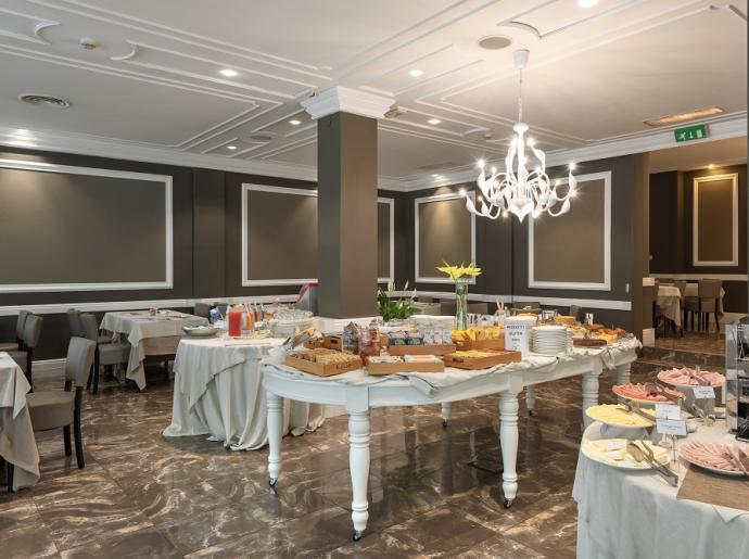 Eleganter Frühstücksraum mit vielfältigem Buffet und gedeckten Tischen.