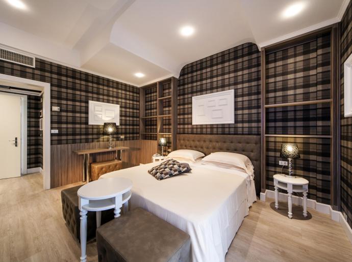 Camera da letto moderna con pareti a quadri e arredamento elegante.