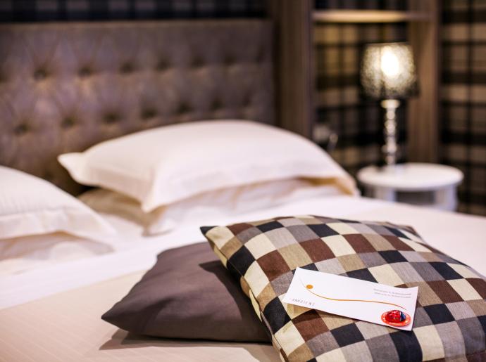 Camera da letto accogliente con cuscini a quadri e lampada sul comodino.