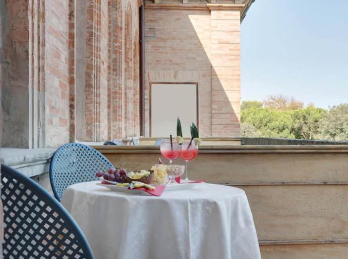 Tavolo con bevande e snack su una terrazza soleggiata.