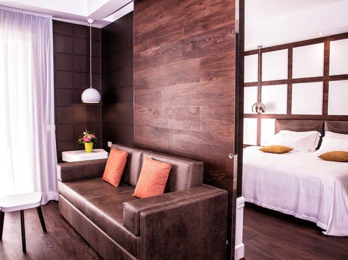 Camera moderna con divano, letto matrimoniale e decorazioni eleganti.