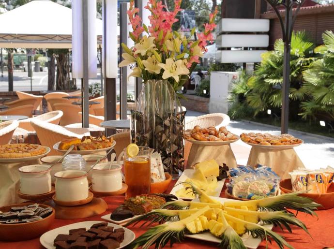 Buffet all'aperto con dolci, frutta e bevande.